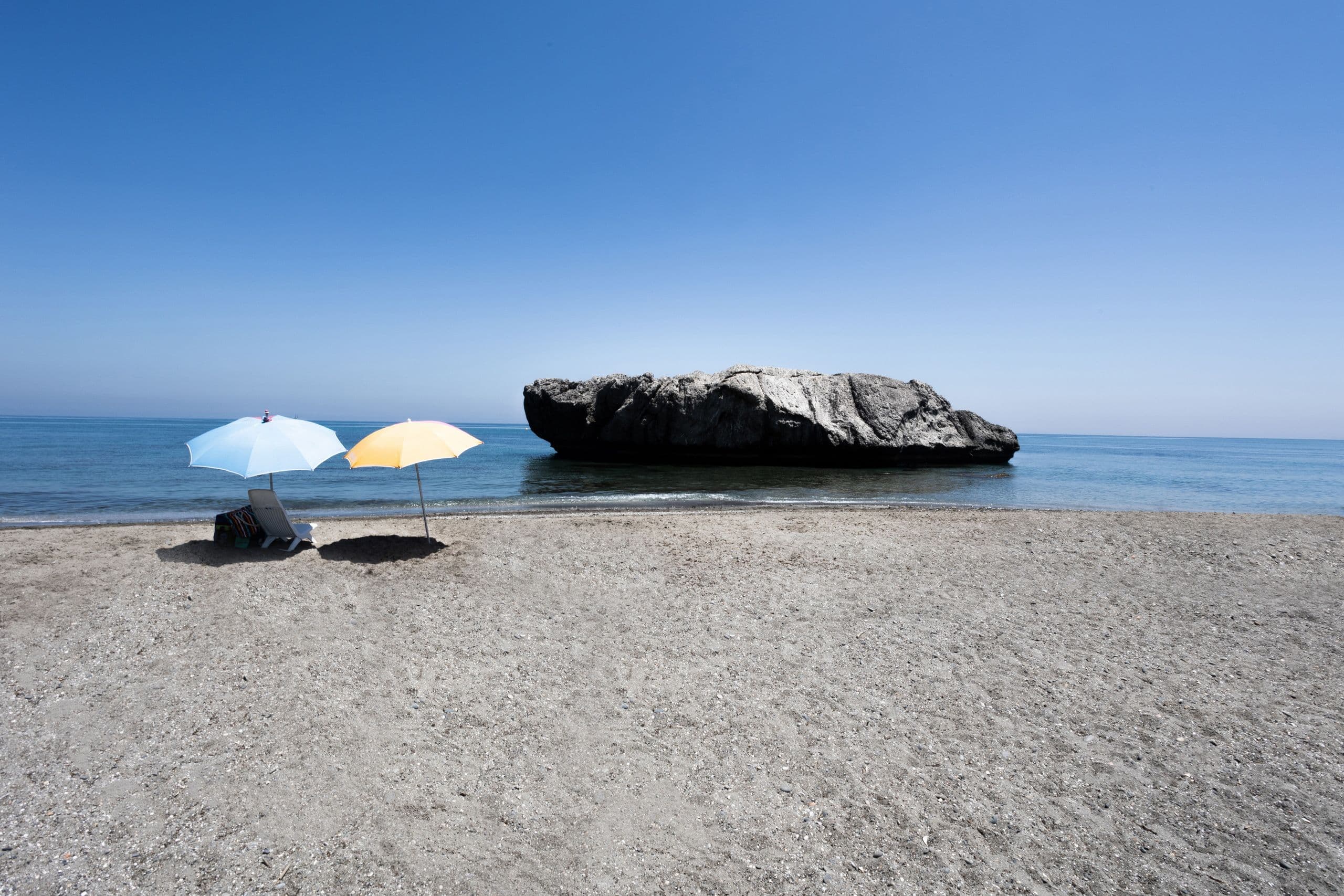 Parasols et rocher solitaire